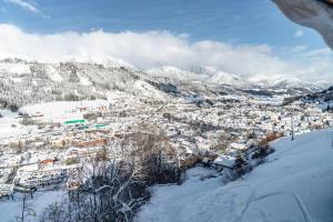 a town in the snow with mountains in the background at Panorama Lodge Premium Apartments in Schladming