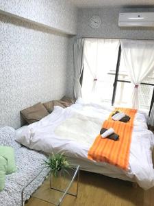 a bedroom with a bed with two phones on it at Dotonbori Condo♡Shinsaibashi 302 (100-3) in Osaka