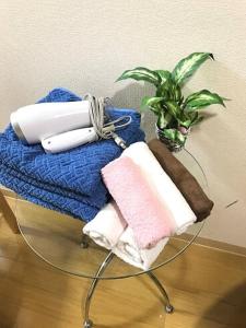 a glass table with towels and a potted plant at Dotonbori Condo♡Shinsaibashi 302 (100-3) in Osaka