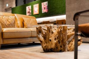 un soggiorno con divano e tavolino da caffè con ceppi di albero di WELLSTAY Namba ad Osaka