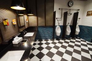 a bathroom with two urinals and a checkered floor at Central Park Reef Resort in Olongapo +22 photos