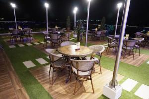 a group of tables and chairs on a patio at night at Central Park Reef Resort in Olongapo