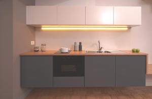 a kitchen with white cabinets and a sink at Hotel Piazza Bellini & Apartments in Naples