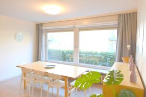 a dining room with a table and a large window at Point Break in Oostduinkerke