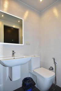 a white bathroom with a sink and a toilet at Freedom Apartment on Nalbandyan street in Yerevan