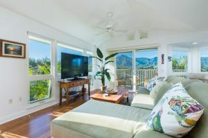 a living room with a couch and a flat screen tv at Villas of Kamalii 47 home in Princeville