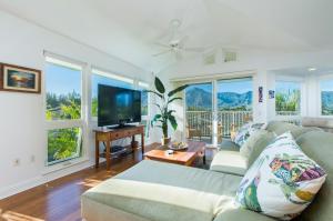 sala de estar con sofá y TV de pantalla plana en Villas of Kamalii 47 home en Princeville