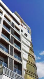a tall white building with balconies on it at Central Park Reef Resort in Olongapo