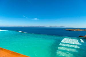 a swimming pool with a view of the water at Villa Selini in Kouroúpi