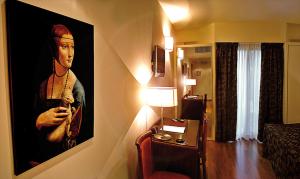 una camera d'albergo con il dipinto di un uomo che tiene in braccio un cane di Hotel Ristorante Il Gambero a Porto SantʼElpidio