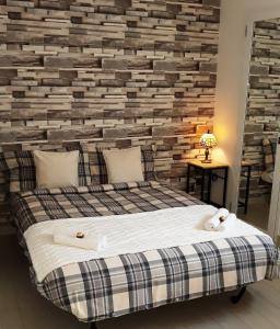 een slaapkamer met een bakstenen muur en een bed bij Nadine Penthouse Studio in Napels