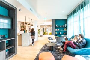 a group of people sitting in a living room at Hôtel The Originals City Le Berry - proche centre-ville - Gare in Bourges