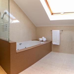 a bathroom with a bath tub and a skylight at Hotel Sercotel Tres Luces in Vigo