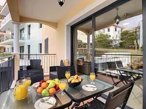 een eetkamer met een tafel met fruit op een balkon bij Apartment Lotus by LovelyStay in Funchal