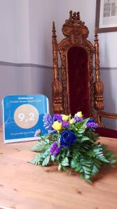 - un bouquet de fleurs sur une table à côté d'une chaise dans l'établissement CharmeRooms Villa Moroni, à Stezzano