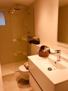 a bathroom with a toilet and a sink and a shower at Can Estrellas apartamento vista mar in Begur