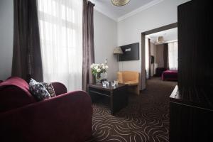a hotel room with a couch and a table with flowers at Hotel Racibor in Racibórz
