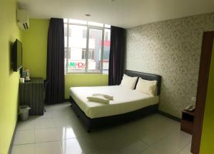 Een bed of bedden in een kamer bij SARIKEI GARDEN HOTEL