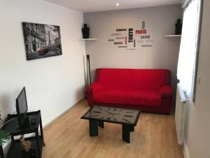 a living room with a red couch and a table at Appartement Granville in Granville