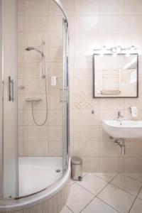 W łazience znajduje się prysznic i umywalka. w obiekcie Hotel Racibor w mieście Racibórz
