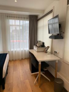 een hotelkamer met een bureau en een bed bij PH93 Amsterdam Central in Amsterdam