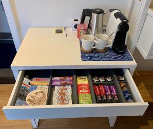 a white table with a drawer full of food and drinks at PH93 Amsterdam Central in Amsterdam