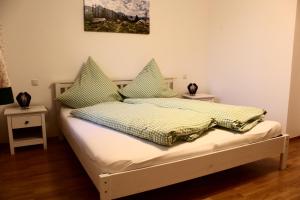 a bedroom with a bed with green and yellow pillows at Saliterhof in Warngau