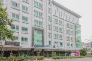 a large white building with blue writing on it at Collection O 7 Hotel Melawai in Jakarta