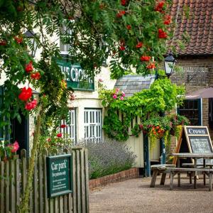 un edificio con un cartello e una panchina davanti di Flint Cottage a Gayton