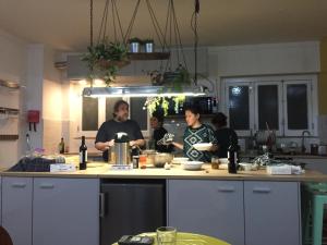 un groupe de personnes dans une cuisine préparant la nourriture dans l'établissement Draft Hostel & Rooms, à Lisbonne