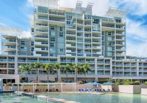 a large building with a pool in front of it at Pelican Waters Resort in Caloundra