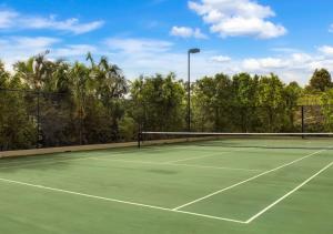 a tennis court with a net on top of it at Pelican Waters Resort in Caloundra