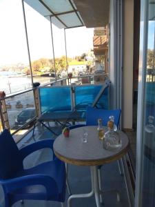 une table et des chaises sur le balcon d'un bateau dans l'établissement Blue Studios, à La Canée