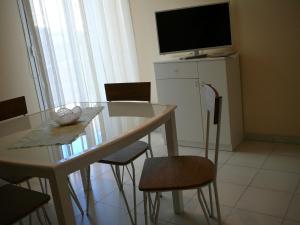 een eettafel met stoelen en een televisie bovenop bij Casa Mia locazione turistica in Ragusa