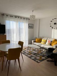 ein Wohnzimmer mit Sofa und Tisch in der Unterkunft Vallon 3 pièces avec balcon in Trouville-sur-Mer