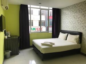 een bed in een kamer met een raam en een bed sidx sidx sidx bij SARIKEI GARDEN HOTEL in Sarikei