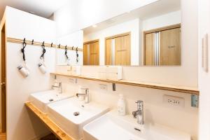 a bathroom with two sinks and a mirror at Ten to Ten Hostel in Sapporo +1 photo