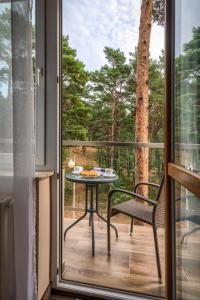 um pátio com uma mesa e uma cadeira na varanda em PONIK Apartamenty przy plaży em Pogorzelica