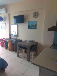 une salle à manger avec une table et une horloge au mur dans l'établissement Blue Studios, à La Canée