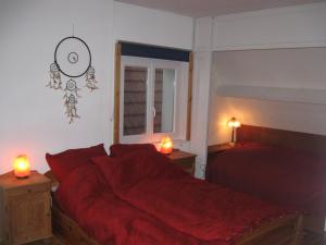 una camera da letto con un letto con lenzuola rosse e due lampade di Familiensuite, zwei Zimmer, Mitbenutzung von Küche und Bad a Rott