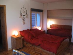 una camera da letto con un letto con lenzuola rosse e una finestra di Familiensuite, zwei Zimmer, Mitbenutzung von Küche und Bad a Rott