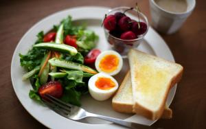 a plate of food with an egg and a salad at Mildom City Hotel in Almaty