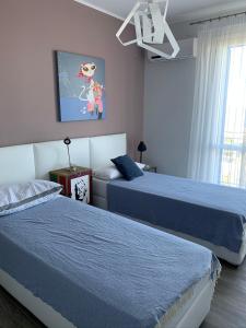 sypialnia z 2 łóżkami i obrazem na ścianie w obiekcie casa Cuffa w mieście San Vito lo Capo