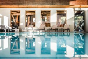 - une piscine avec des chaises à côté d'un bâtiment dans l'établissement Hotel Waldsee, à Fiè