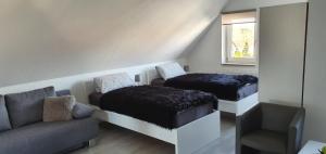 a room with two beds and a couch and a window at Unique Messe - Airport in Steinenbronn