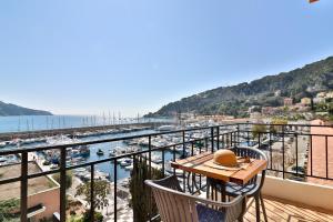 a balcony with a table and chairs and a view of a harbor at Hotel De La Darse in Villefranche-sur-Mer
