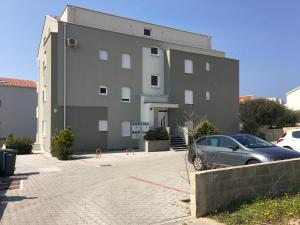a building with a car parked in front of it at Apartment Emmy in Novalja