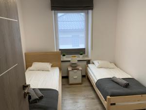 スカルジスコ・カミエンナにあるPokoje ANTRACYTの窓付きの小さな部屋のベッド2台