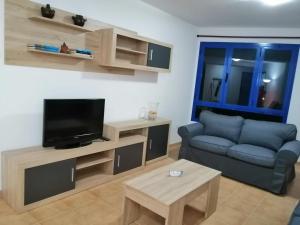 ein Wohnzimmer mit einem Sofa und einem TV in der Unterkunft Mirador de Alegranza in Orzola