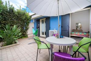a table and chairs with an umbrella on a patio at House Rita Marzamemi in Marzamemi